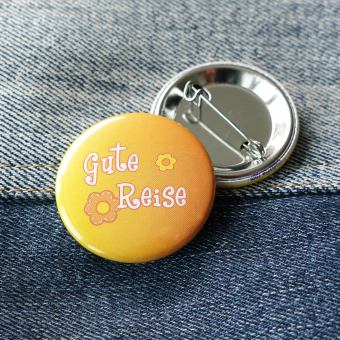 Ansteckbutton Gute Reise auf Jeans mit Rückseite